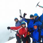 Team pose at the top of a peak